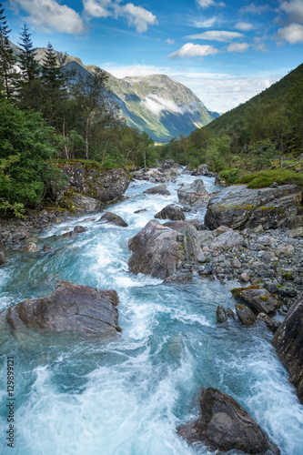 Norwegian landscape with milky blue glacier river near Trollstigen photo