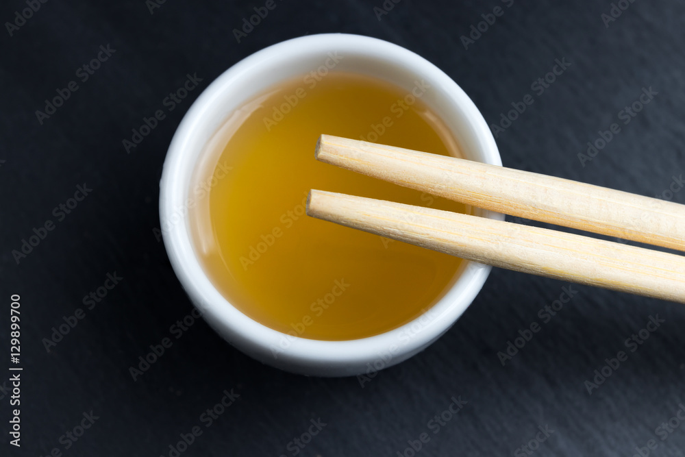 Fish sauce in small white bowl with chopsticks. Fish sauce in small white bowl with chopsticks.