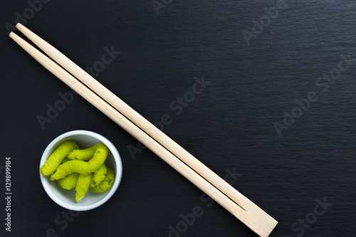 Japanese horseradish wasabi in small white bowl with chopsticks.