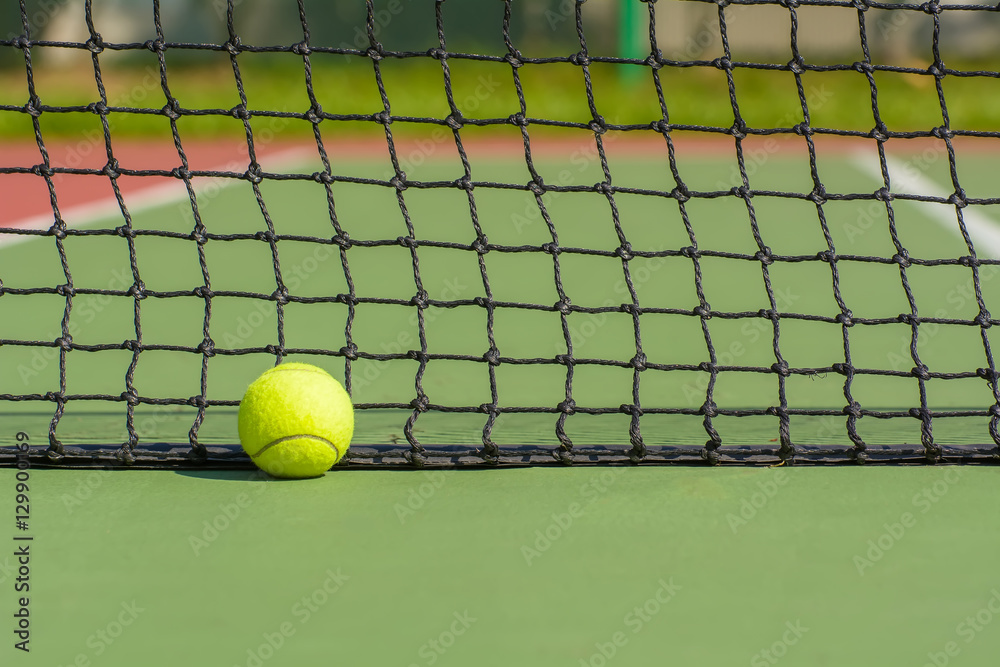 Green tennis balls are in a tennis court.