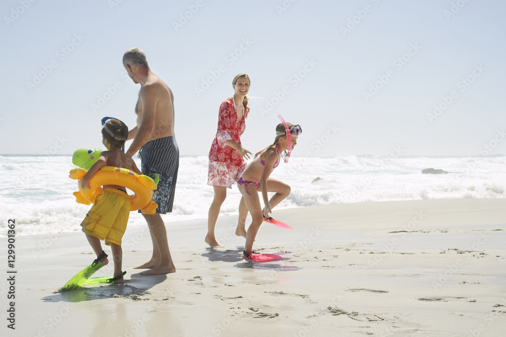 Fototapeta premium Happy children wearing scuba equipment while standing with parents at beach