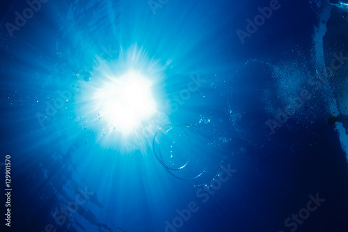 Air bubbles in shape of rings underwater of blue sea in light of sun © willyam