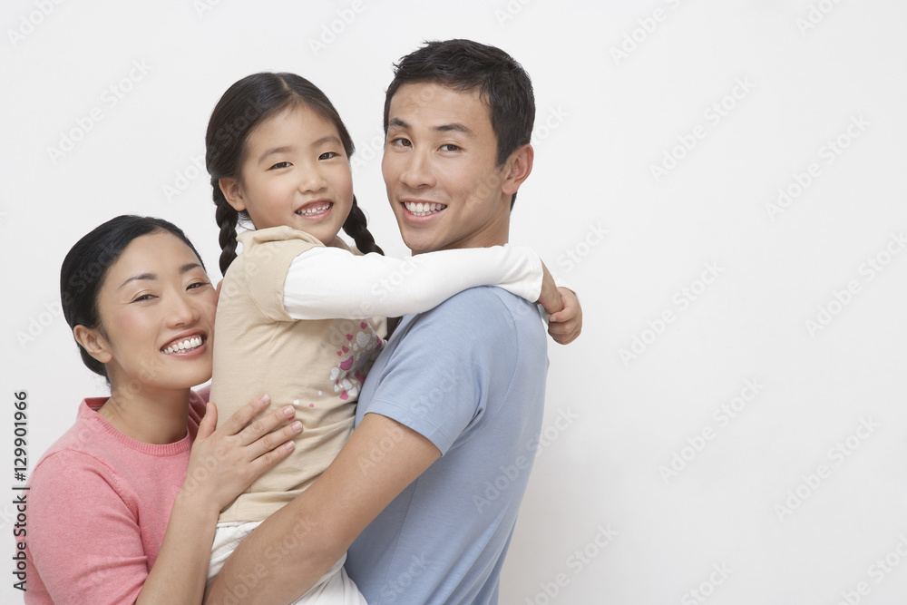 Portrait of a young couple with daughter against white background Portrait of a young couple with daughter against white background