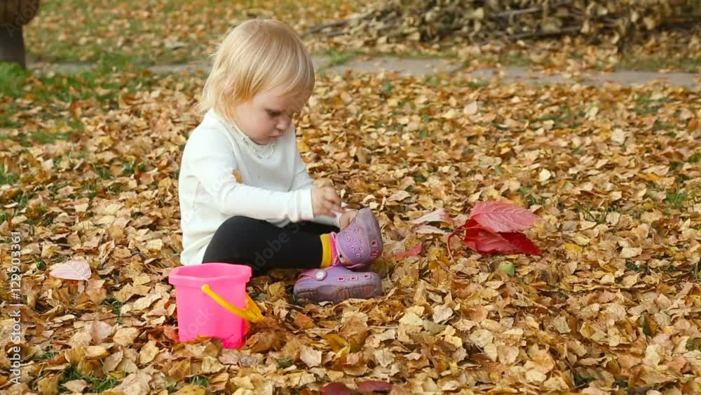 Cute baby girl playing with leaves in autumn Cute baby girl playing with leaves in autumn