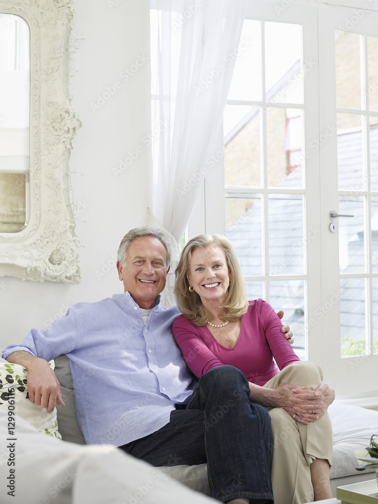 Portrait of a relaxed and smiling mature couple in white home interior Portrait of a relaxed and smiling mature couple in white home interior