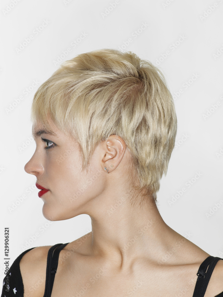 Side view closeup of beautiful young woman with red lips looking away on white background Side view closeup of beautiful young woman with red lips looking away on white background