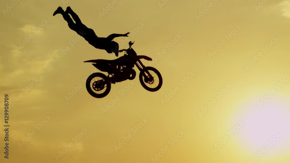 SLOW MOTION: Extreme pro motocross biker jumping freestyle trick over the sun SLOW MOTION: Extreme pro motocross biker jumping freestyle trick over the sun