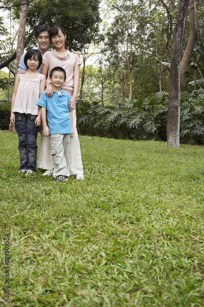 Full length portrait of happy parents with children in park