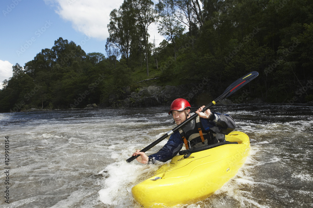 View of a young man kayaking in river