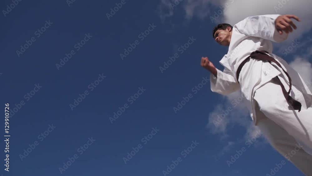 Young people, athlete, sport activity, combat and extreme sports, hispanic man exercising in karate and traditional martial arts, jumping in the sky Young people, athlete, sport activity, combat and extreme sports, hispanic man exercising in karate and traditional martial arts, jumping in the sky