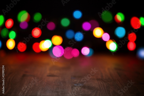 Christmas colorful defocused lights background and wooden table