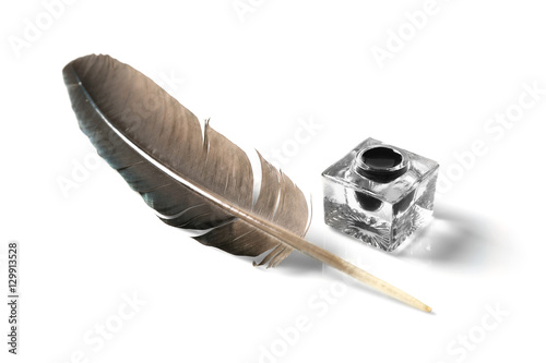Feather pen and inkwell isolated on white