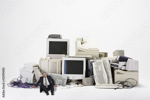 Картината върху платно Digital composite of businessman sitting by various obsolete technologies agains
