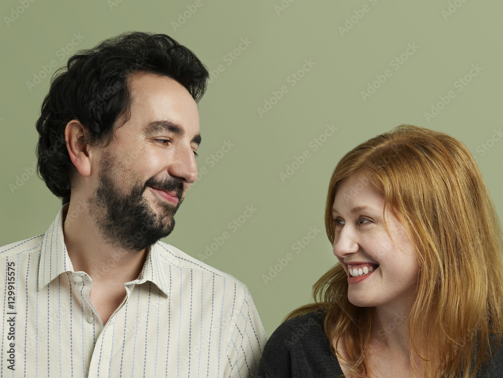 Closeup of happy loving couple looking at each other on colored background Closeup of happy loving couple looking at each other on colored background