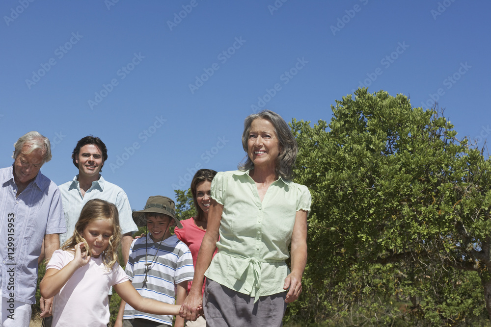 Happy three generation family walking against clear blue sky Happy three generation family walking against clear blue sky