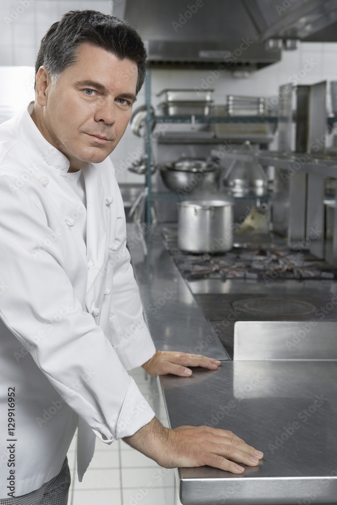 Portrait of a confident male chef standing in the kitchen Portrait of a confident male chef standing in the kitchen