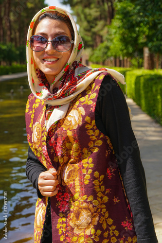 Young Iranian woman in fashionable modern clothes, Bagh-e Dolat garden, Yazd, Iran photo