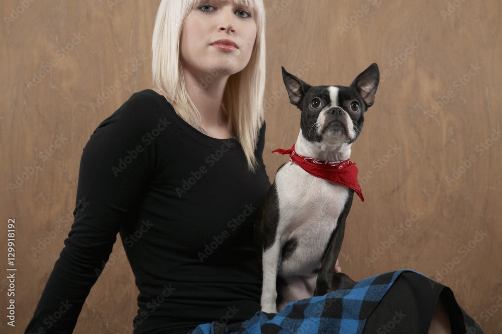Portrait of beautiful young woman with Bulldog over colored background