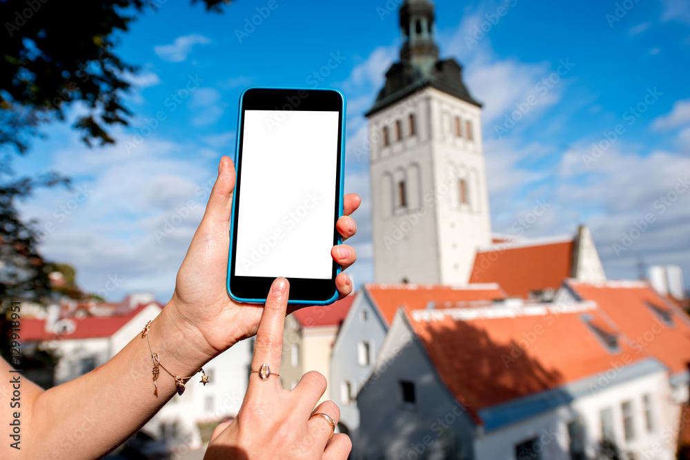 Naklejka premium Phone with white screen on the old town background in Tallinn, Estonia
