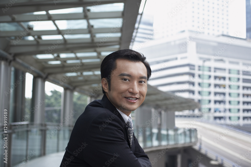 Portrait of confident businessman standing on footbridge