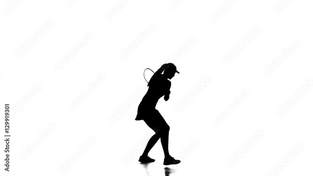 Woman beats the ball great racket while jumping sideways. Silhouette Woman beats the ball great racket while jumping sideways. Silhouette