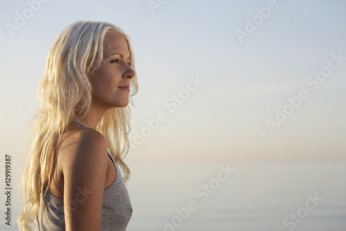 Side view of beautiful young woman standing on beach © moodboard