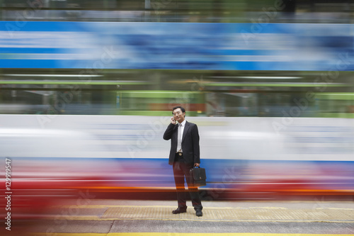 Photography Full length of businessman using cell phone on busy street