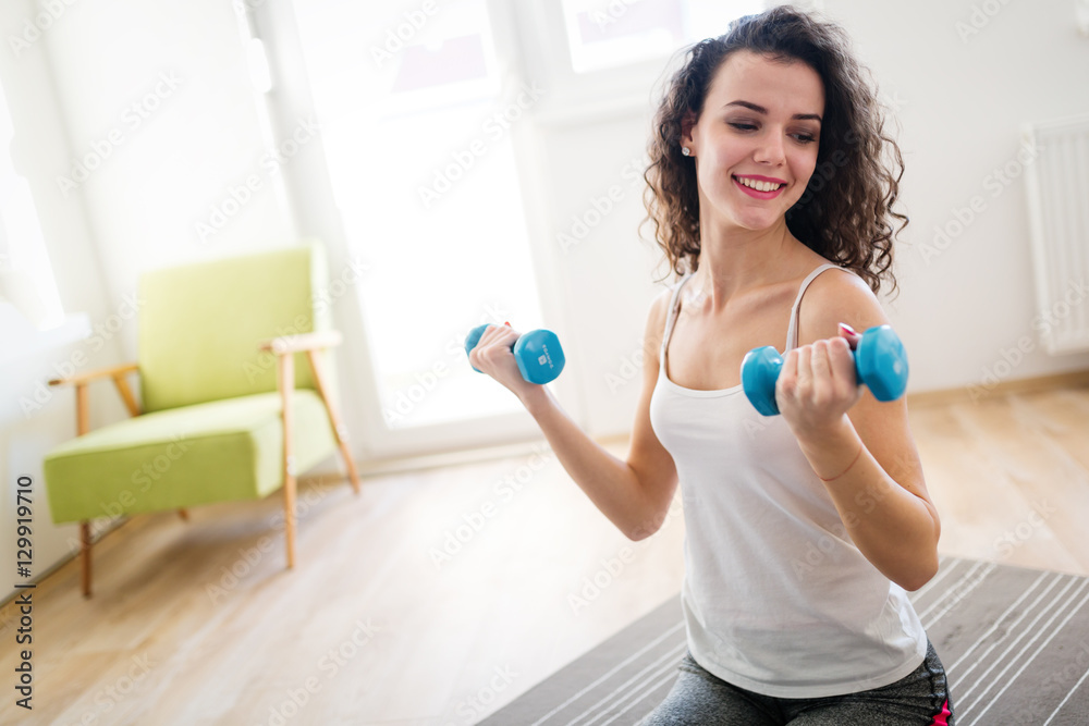 Sporty woman exercising at home to stay fit