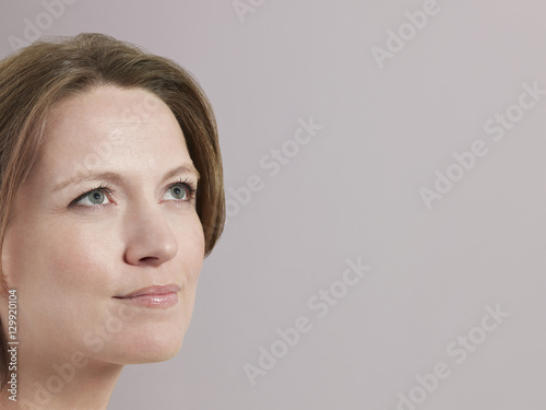 Closeup of beautiful woman looking at copyspace on colored background