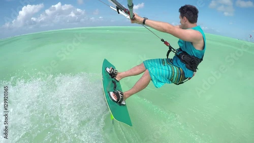 CLOSE UP: Cheerful young kiteboarder kiting in perfect blue lagoon on Zanzibar
