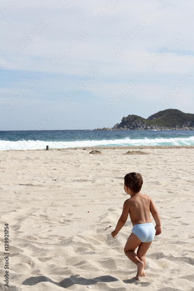 boy running towards the sea on the sand