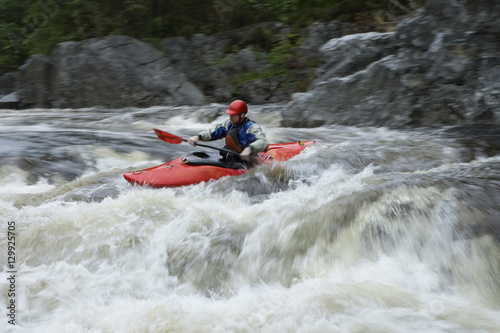 Side view of a man kayaking in rough river
