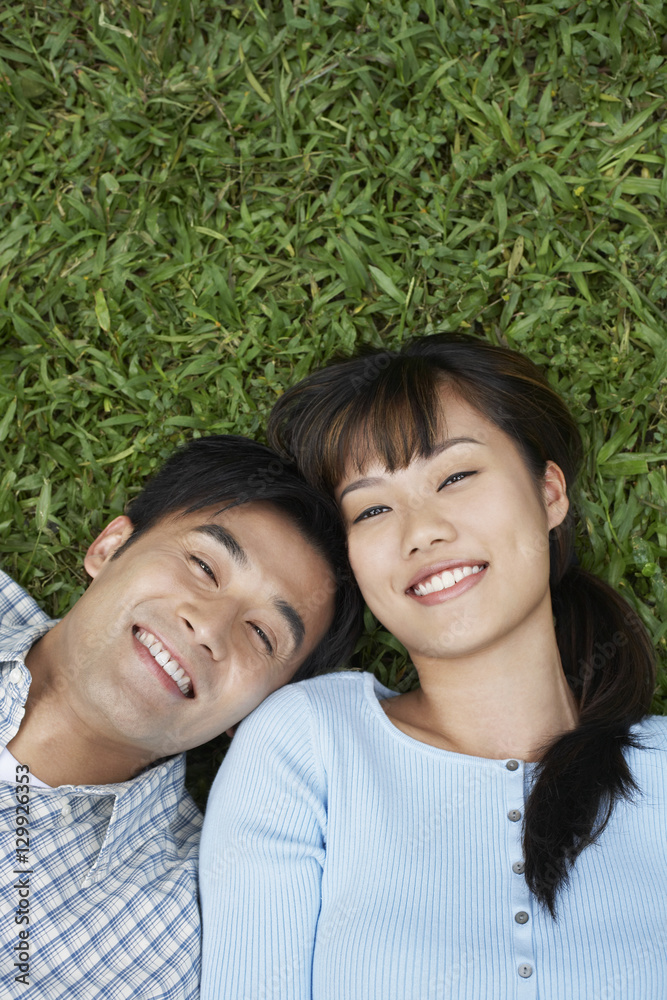 Elevated view of happy couple lying on grass Elevated view of happy couple lying on grass