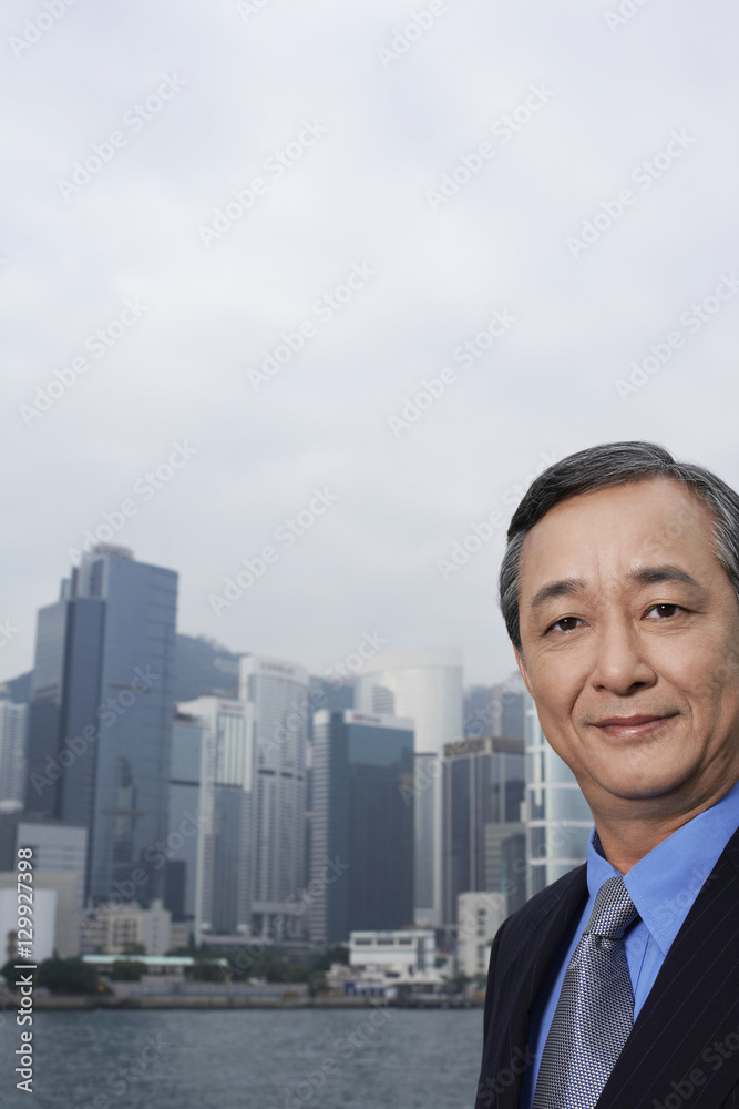 Closeup portrait of confident middle aged businessman with cityscape in background Closeup portrait of confident middle aged businessman with cityscape in background