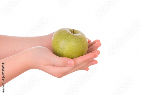A young man holds a juicy green apple in the hands.
