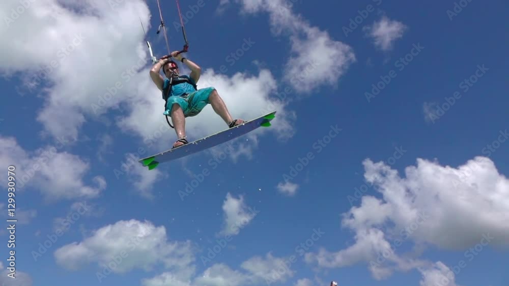 SLOW MOTION: Kite surfer has fun jumping over camera, splashing water drops SLOW MOTION: Kite surfer has fun jumping over camera, splashing water drops