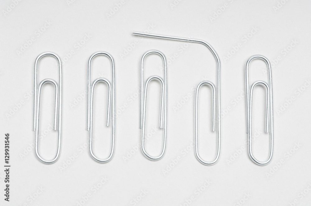 Row of steel paperclips with broken clip over white background Row of steel paperclips with broken clip over white background