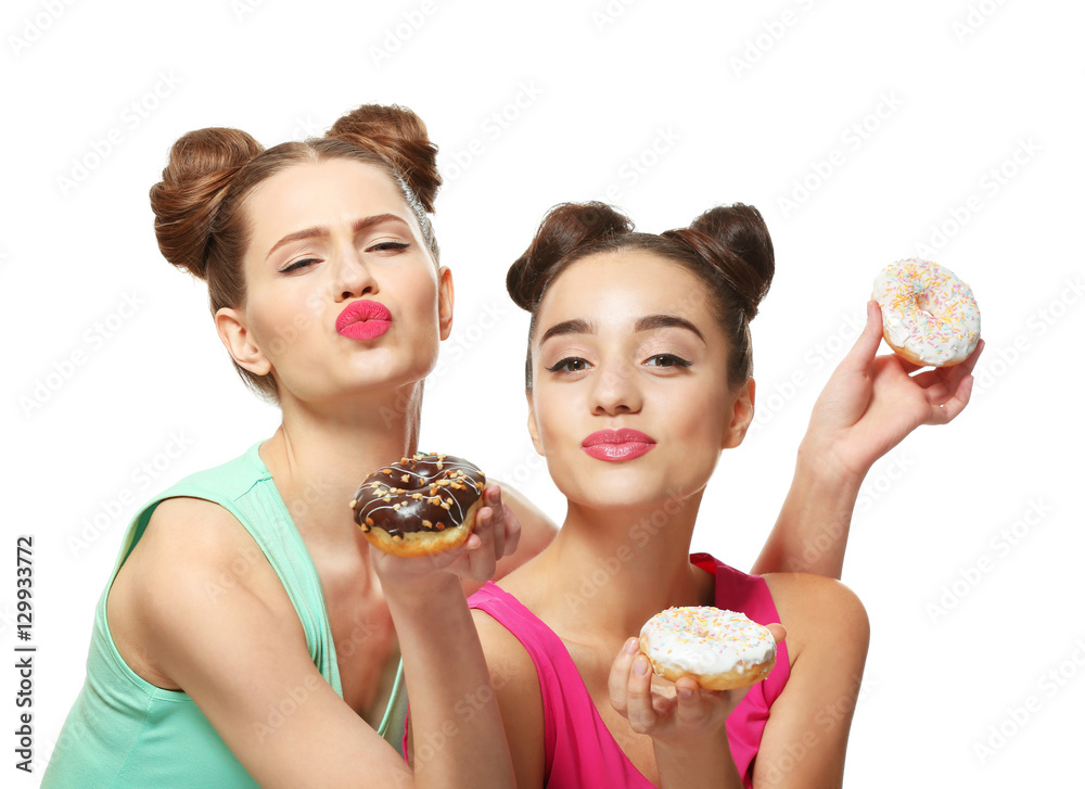 Funny young women with tasty donuts on white background Funny young women with tasty donuts on white background
