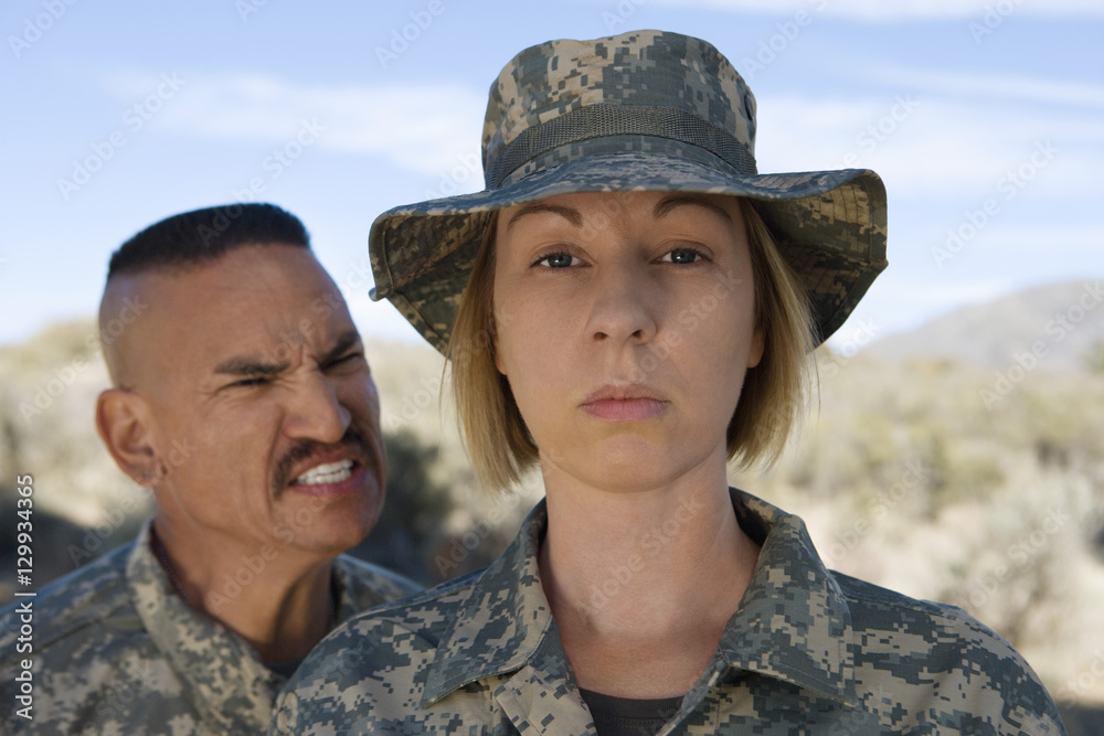 Military officer yelling at female soldier during a training session Military officer yelling at female soldier during a training session
