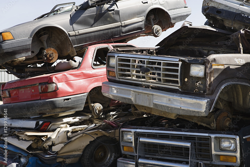 Obraz premium Stack of worn out and broken¬†down cars at junkyard