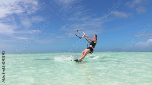 SLOW MOTION: Happy smiling surf girl kitesurfing on beautiful ocean surface