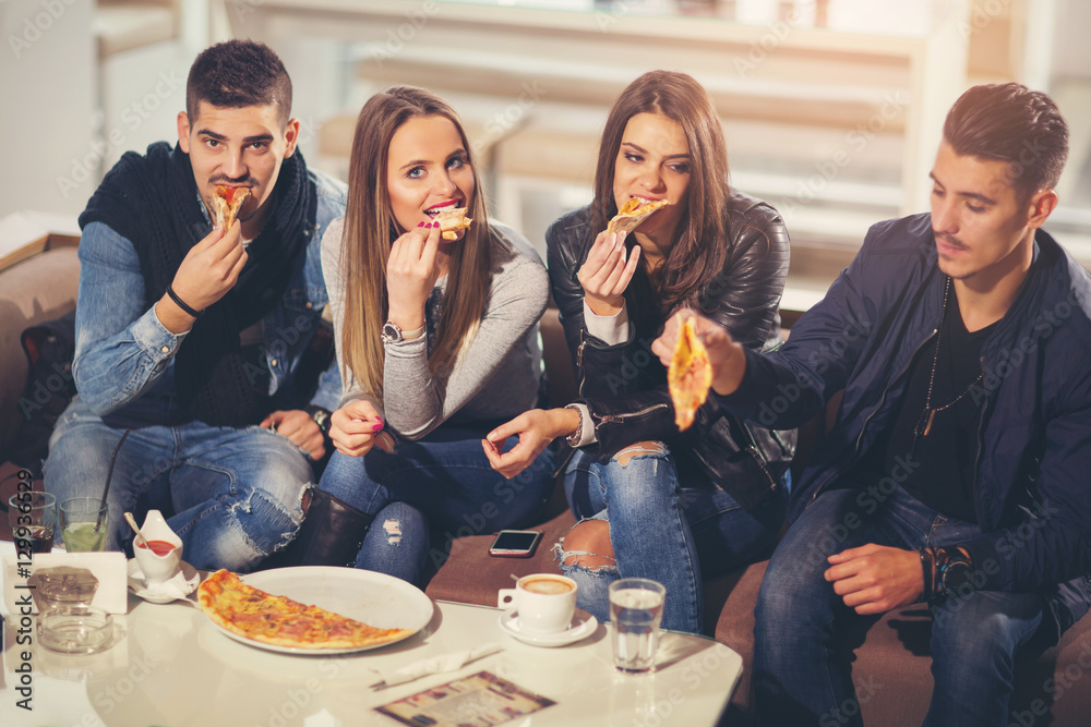 Obraz premium Young people in casual clothes eating pizza, talking