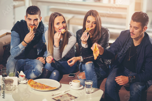 Young people in casual clothes eating pizza  talking