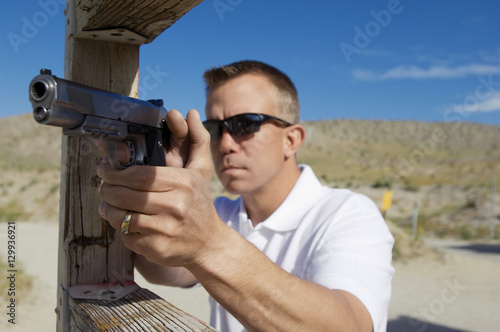 Man aiming handgun at firing range during weapons training