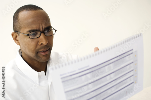 An African American businessman reading document in office