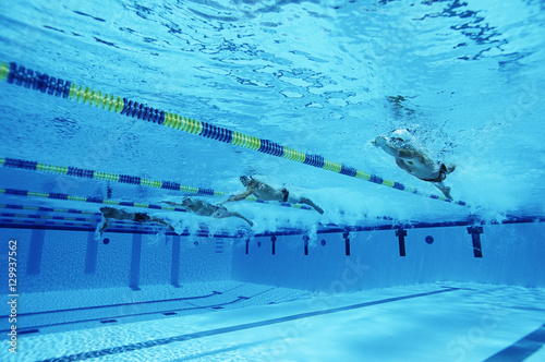 Swimmers racing together in swimming pool