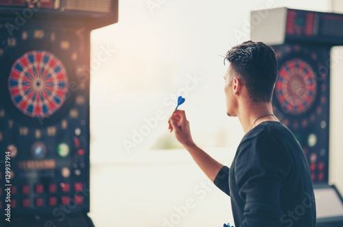 Принти на полотні Young man playing a game shooting darts
