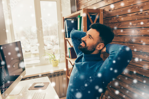 Young worker having break on snowy xmas background