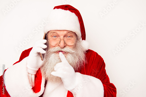 Portrait of happy Santa Claus talking on phone and showing shh g photo