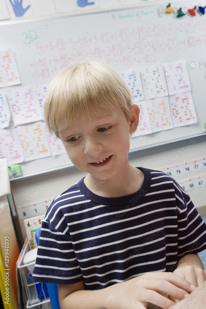 Cute little boy sitting in classroom Cute little boy sitting in classroom